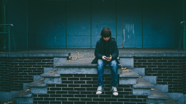 Ein Junge schaut auf sein Smartphone