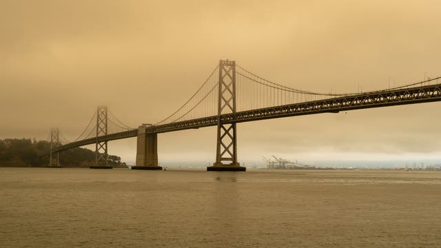 Die Bay Bridge in San Francisco umgeben von Smog durch nahe gelegene Waldbrände. Saubere Luft ist in der Ferne am Hafen von Oakland zu sehen.