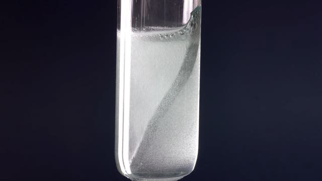 Symbolbild: Metall in Flüssigkeit in Laborkolben