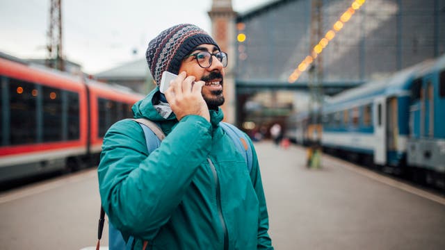 Mann telefoniert am Bahnsteig