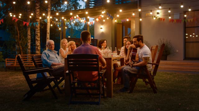 Familie an einem Sommerabend draußen am Tisch