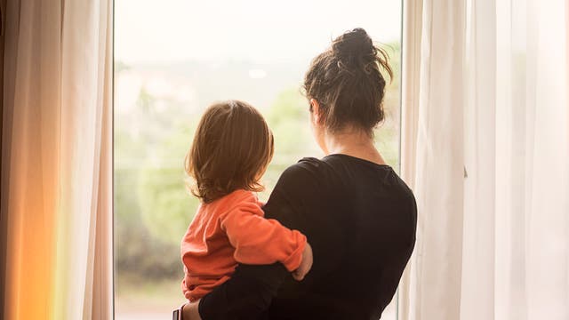Frau und Kind blicken aus dem Fenster