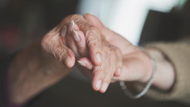 Hände eine älternen und einer jüngeren Frau, die sich gegenseitig halten