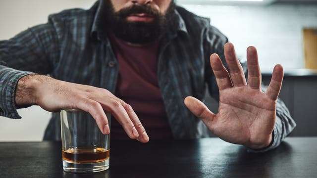 Ein Mann versucht, seinen Drang zum Alkohol in Griff zu bekommen