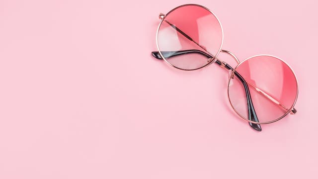 Rosafarbene Brille auf rosafarbenem Hintergrund