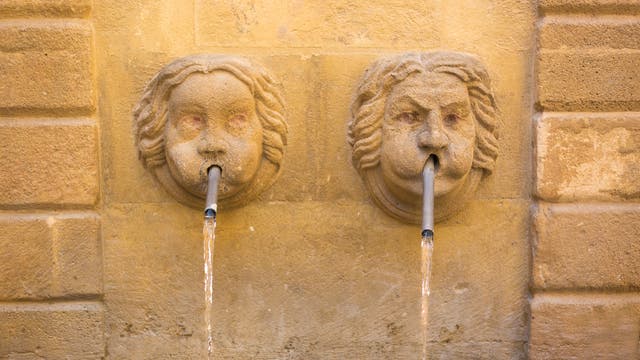 Zwei kuriose gesichtsförmige Wasserspeier speien Wasser.