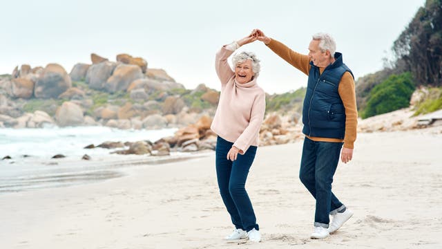 Älteres Paar tanzt am Strand