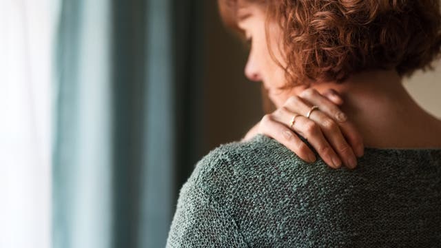 Frau mit Nackenschmerzen