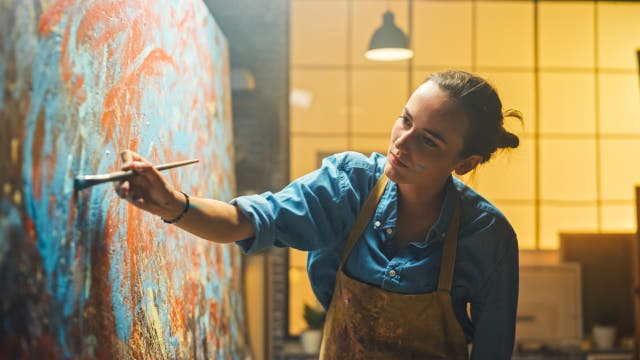 Junge Frau malt ein abstraktes Gemälde