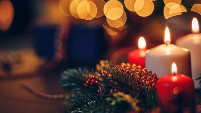 Kerzen brennen auf einem Adventsgesteck