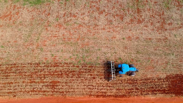 Ein Traktor ackert in Brasilien den Boden auf für den Sojaanbau.
