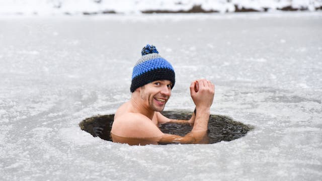 Mann badet in zugefrorenem See