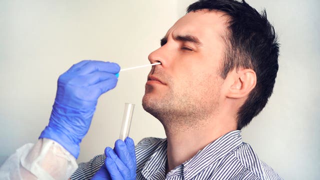 Ein Arzt nimmt einen Nasenabstrich von einem Mann.