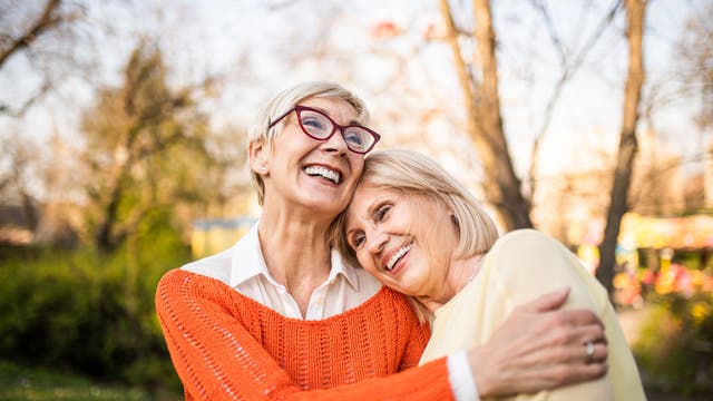 Zwei ältere Frauen sind im Park und lachen gemeinsam