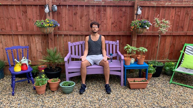 Ein Mann meditiert auf der Gartenbank im Hinterhof