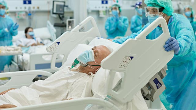 Beatmeter älterer Mann im Krankenbett wird von medizinischem Personal geschoben-