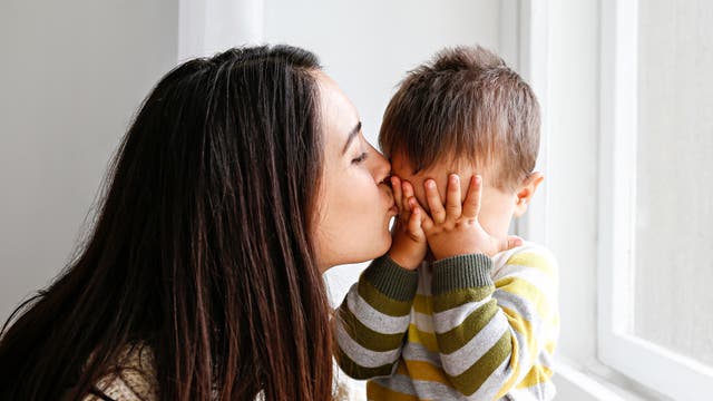Mutter gibt weinendem Kind ein Küsschen