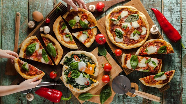 Pizzastücke unterschiedlicher Größe auf einem Tisch