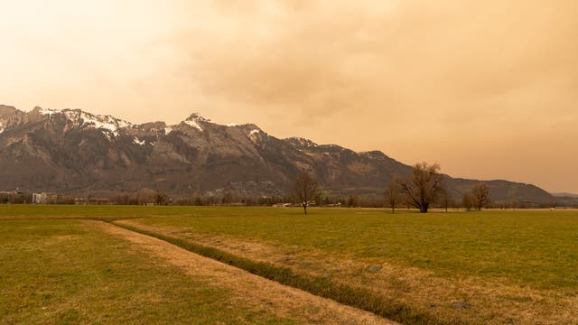 Saharastaub färbt den Himmel über dem Rheintal in Liechtenstein gelblich.