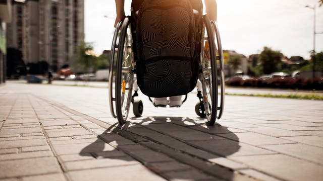 Von Multiple-Sklerose betroffen und im Rollstuhl sitzend