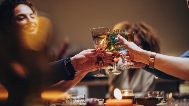 Eine Gruppe Menschen stößt mit alkoholischen Getränken an