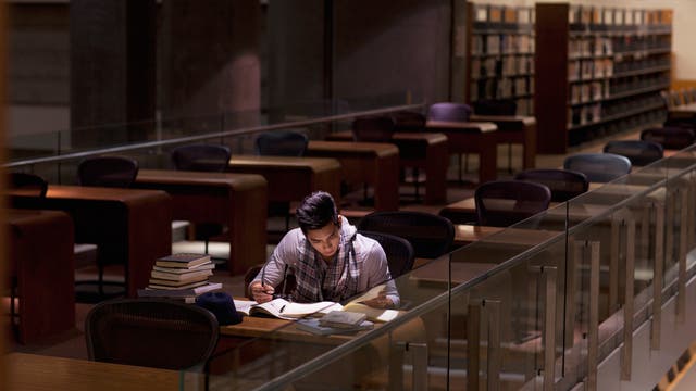 Student lernt spätabends in der Bibliothek 