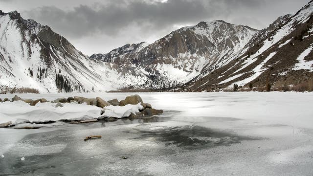 Vereister See vor schneebedeckten Bergen