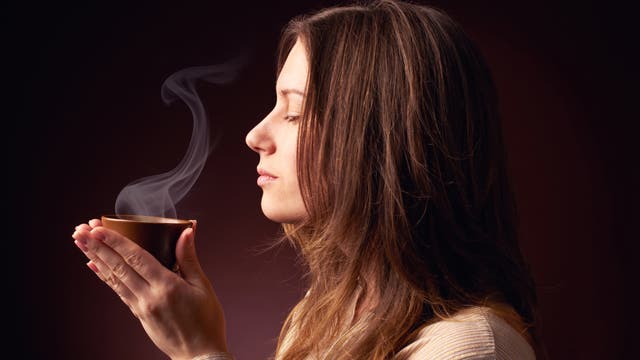 Frau mit duftender Tasse Kaffee in der Hand