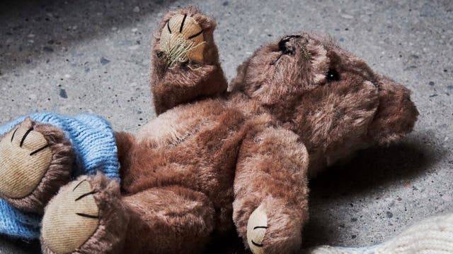 Ein Teddybär liegt auf der Straße