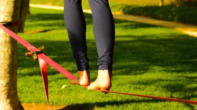 Nackte Füße balancieren auf einem Seil im Park