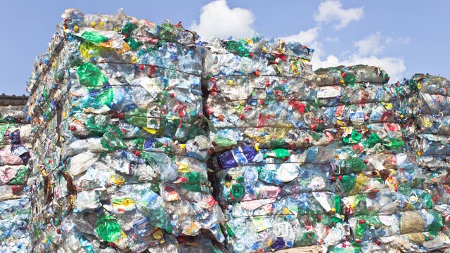 Mehrere große, verschnürte Pakete gesammelter Plasktikflaschen zum Recyceln