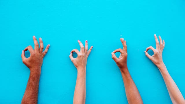Vier Hände geben das Okay-Zeichen