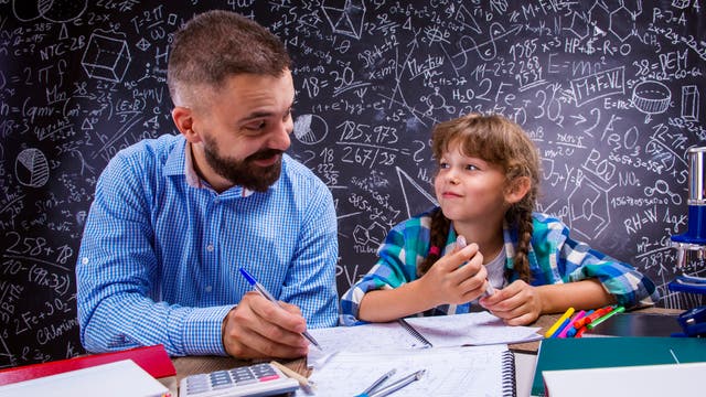 Lehrer und Schülerin haben Spaß am Lösen von Matheaufgaben