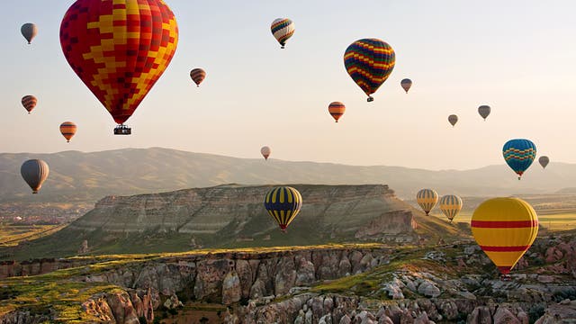 Heißluftballons fliegen über eine Landschaft