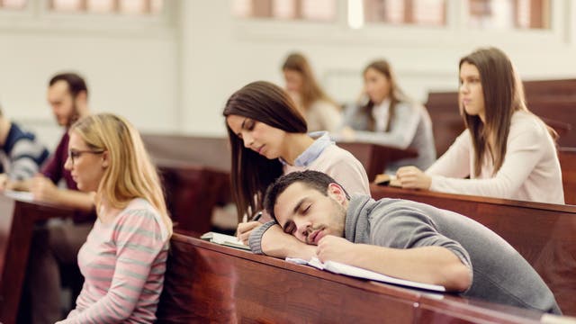 Student liegt schlafend in der Vorlesung