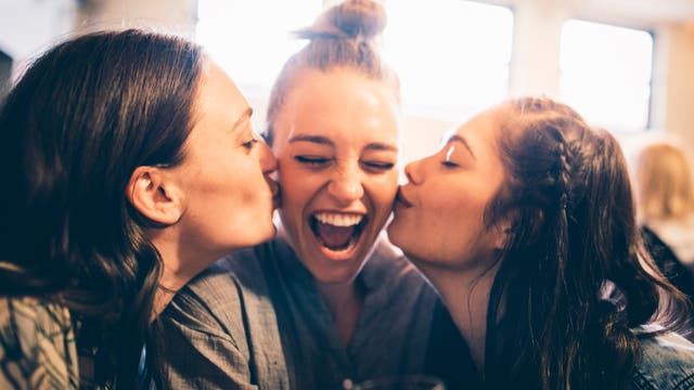 Drei Freundinnen lachen zusammen