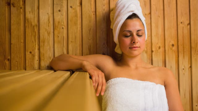 Frau genießt mit geschlossenen Augen ein Saunabad