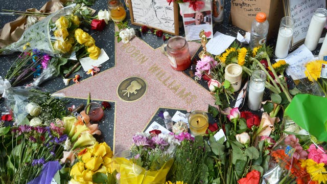 Trauernde legen am Walk of Fame Blumen auf dem Stern von Robin Williams nieder.
