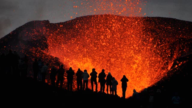 Eine Gruppe von lebensmüden Knalltüten steht direkt am Krater eines aktiven Vulkans.