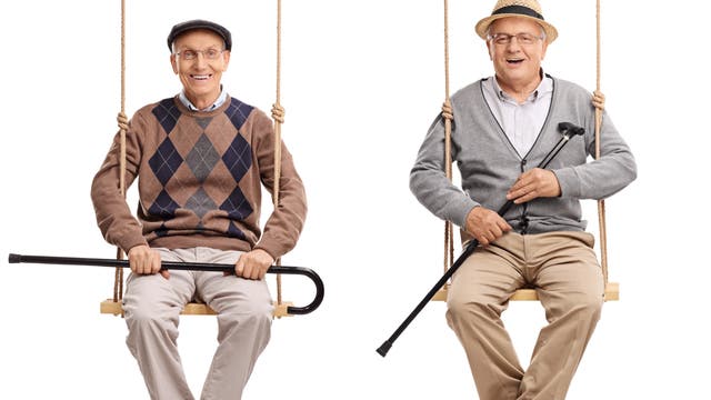 Zwei alte Männer sitzen fröhlich auf Schaukeln