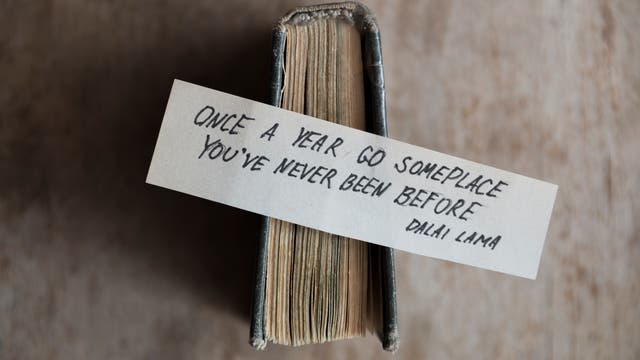 Ein Zettel mit der Aufschrift: »Once a year go someplace you've never been before.» (Dalai Lama)