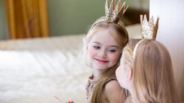 Kleine Prinzessin bewundert im Spiegel ihren frisch aufgetragenen Lipgloss