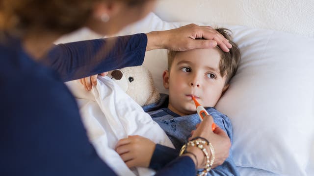 Bei einem kleinen Jungen wird Fieber gemessen.