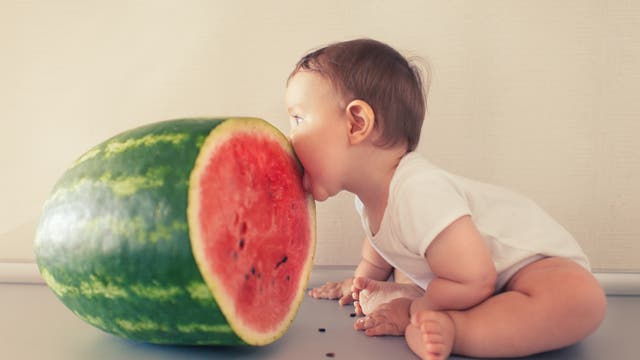 Kleinkind isst eine Melone