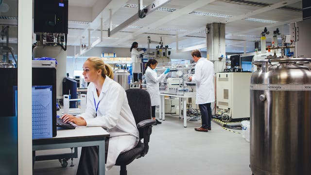 Eine gruppe von Fachleuten in einem Labor, das für medizinisch-pharmazeutische Forschung ausgestattet ist.