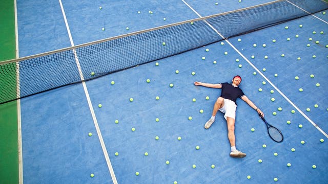 Ein Tennisspieler auf einem blauen Tennisplatz.