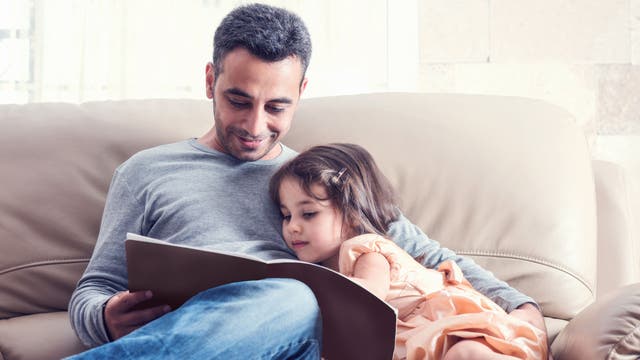 Ein Vater liest seiner Tochter aus einem Buch vor