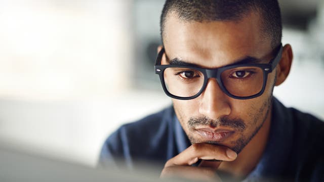 Mann schaut konzentriert auf seinen Computerbildschirm