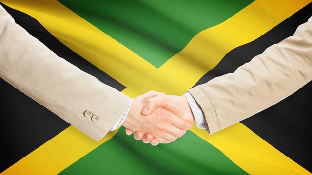 Handschlag vor der Jamaikaflagge