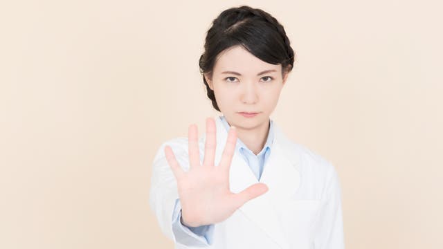 Frau macht ein Stopp-Handzeichen